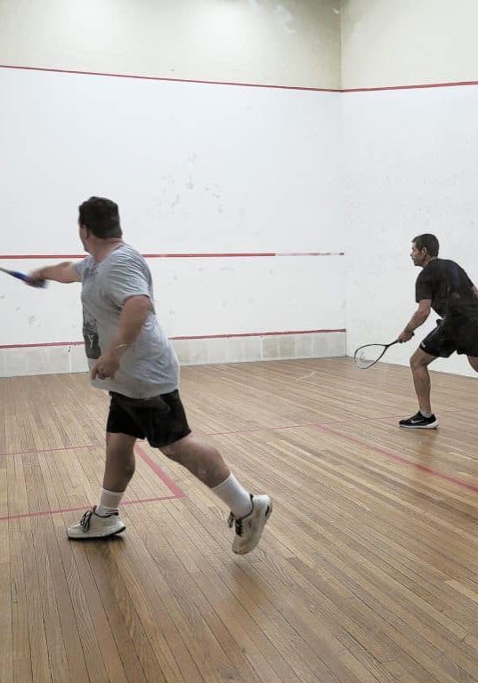 Michael M plays a backhand against Michael H. Michael M plays a backhand against Michael H.